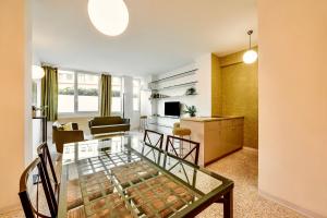 een woonkamer met een glazen tafel in een kamer bij Apartments Navigli Center in Milaan