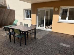 a wooden table and chairs on a patio at Le Lorain cozy avec terrasse in Épinal