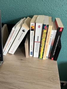 a group of books sitting on a book shelf at Le Lorain cozy avec terrasse in Épinal