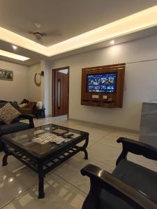a living room with a coffee table and a tv at 2BHK Flat Rishikesh Ganga Bhumi- Kaphal Nest in Rishīkesh