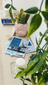 a table with a potted plant and cards on it at Gevihome in Capua
