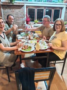 a group of people sitting at a table eating food at TamCoc Moon An Bungalow & Cafe in Ninh Binh