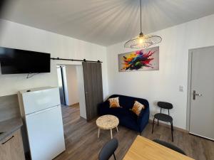 a living room with a blue couch and a tv at Bienvenue au Quai 29 in Épernay
