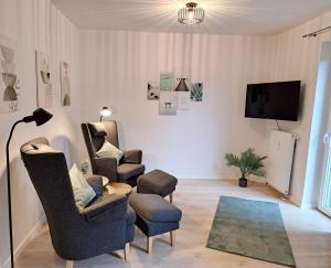 a living room with two chairs and a tv at RegioStyle Apartment an der Müritz in Waren