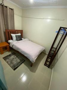 a small bedroom with a bed and a mirror at Matildah's Tranquil Haven in Siaya +3 photos