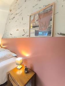 a bedroom with a bed and a table with a lamp at La Maison Rouge sur le port à proximité de toutes commodités 2 personnes in Plérin +8 photos