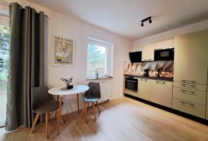a kitchen with a table and chairs in a room at RegioStyle Apartment an der Müritz in Waren