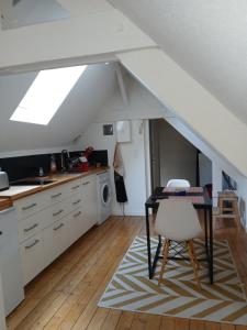 a kitchen with a table and a kitchen under an attic at Le Coucou Rennais in Rennes