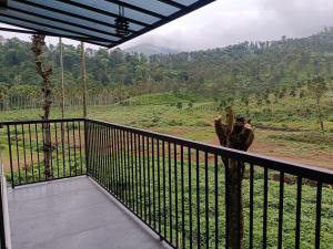 a giraffe standing on a balcony with a view at The Tree House in Vythiri