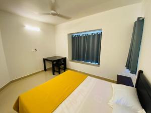 a bedroom with a bed and a table in it at Elenji Dream Villa Homestay in Munnar