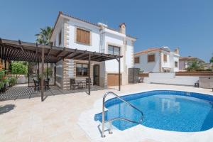 a villa with a swimming pool in front of a house at Malama 28 Villa Ekaterina in Paralimni