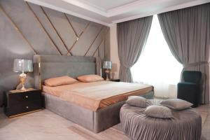 a bedroom with a large bed and a ottoman at Bhurban Homes in Murree