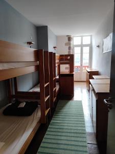 a room with bunk beds and a green rug at Auberge du Pèlerin- Auberge de charme en pierre avec vue sur les montagnes in Saint-Jean-Pied-de-Port