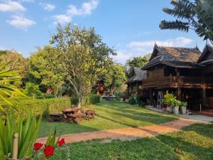 ein Hof vor einem Holzhaus in der Unterkunft Huen Tip Viman in Ban Nong Ho