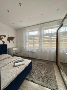 a bedroom with a bed and a large window at Apartament Ząbki in Ząbki
