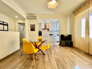 a kitchen and dining room with a table and yellow chairs at 25 minutes MILANO DUOMO Elegant Apartment Center Sesto in Sesto San Giovanni