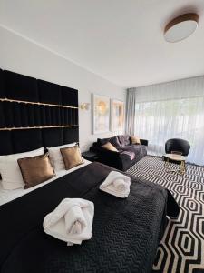 a bedroom with a large bed and a couch at Apartament Solny Resort A032 z klimatyzacją i ogrodem in Kołobrzeg