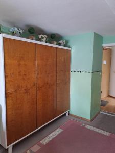 une pièce avec une grande armoire en bois avec des fleurs dessus dans l'établissement Pension Kaufmann Ferienwohnung 2, à Oberwiesenthal