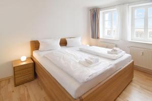 Un dormitorio con una gran cama blanca con dos toallas encima. en Vineta-App-02, en Heringsdorf