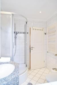 Un baño con ducha, bañera y lavabo. en Vineta-App-02, en Heringsdorf