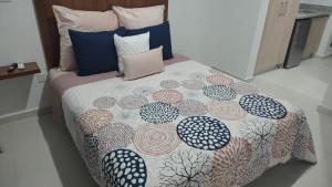 a bed with a comforter and pillows on it at New Oceanfront Apartment in Mazatlán +78 photos