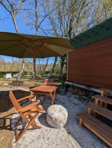 a picnic table and a bench and an umbrella at Tinyhouse Sabrina in Papenburg
