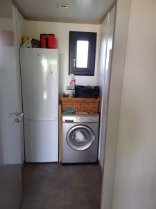 a kitchen with a refrigerator and a washing machine at Marseillan Pomérols loue cottage in Pomérols