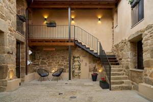 a stone building with two chairs and a staircase at O Campiño Alojamientos Turísticos in Trasmiras