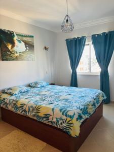 a bedroom with a bed with blue drapes at Armaçao de Pera - T1 Proche Mer et commodités in Armação de Pêra