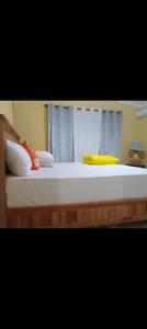 una camera da letto con un grande letto con un cuscino giallo di Hotel vista del mar a Río San Juan
