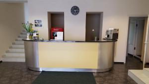 eine Lobby mit einer Theke mit einer Uhr an der Wand in der Unterkunft Hotel Gulbene in Gulbene