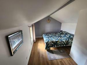 a small bedroom with a bed and a television at Les lavandins d'ASMA in Bollène