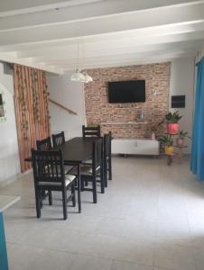 a dining room with a table and chairs and a brick wall at La Esperanza in Salta