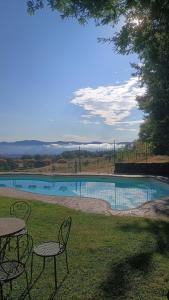 a swimming pool with tables and chairs in a yard at Country House Arborea in Bagnoregio