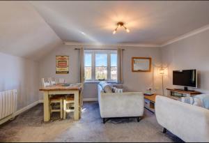 a living room with a table and chairs and a television at Harbour View - Whitby in Whitby