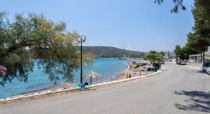 an empty street next to a beach with umbrellas at Vivari apartment in Vivari