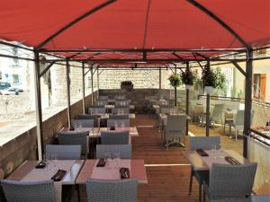 un restaurant avec des tables et des chaises sous une tente rouge dans l'établissement Logis Hotel Cara Sol, à Elne