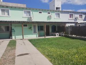 a green and white house with a grass yard at La Esperanza in Salta