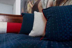 un letto blu con cuscini e un dipinto sul muro di Bohemian Apartment - heart of Como a Como