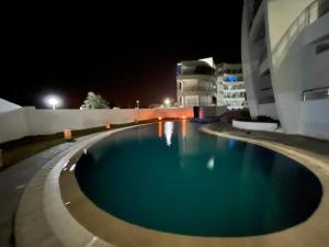 a swimming pool at night next to a building at Hergla Diamant bleu Nadine in Harqalah