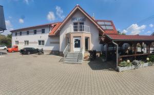 布拉迪斯拉发Hotel Orlan的一座白色的大建筑,前面有一辆汽车