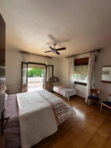 マタラスカニャスにあるMarismas al marのベッド2台と天井ファン付きの寝室