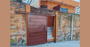 Un edificio de ladrillo con una puerta de garaje marrón. en Suite Nantli, en Antiguo Cuscatlán