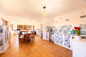 Una cocina y comedor con azulejos azules y blancos. en Villa Casty with private pool, en Trabia