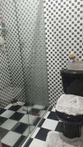 une salle de bain avec toilettes et douche en verre dans l'établissement Casa em vila, à Ananindeua