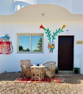 a table and chairs in front of a building at Boutique sea lodge in Nuweiba‘ el Muzeinah