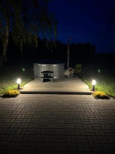 a bench in a park at night with lights at Poilsio oazė Stebuliuose in Stebuliai +14 photos