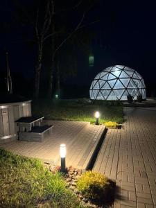 a park with two benches and a dome at night at Poilsio oazė Stebuliuose in Stebuliai
