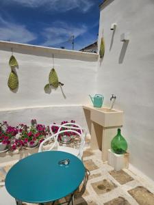 un patio con tavolo blu, sedie e fiori di Ostuni Piccola Dimora a Ostuni
