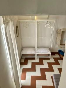 un frigorifero vuoto in una stanza con il pavimento a scacchi di Ostuni Piccola Dimora a Ostuni